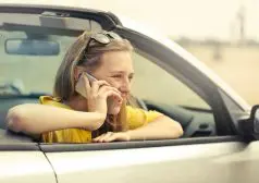 אישה יושבת ברכב ומדברת בטלפון