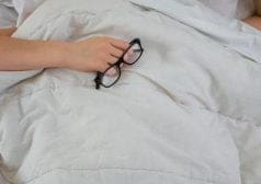 אישה במיטה עם כרית על הראש