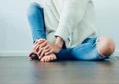אישה הסובלת מכאב יושבת על הרצפה