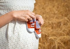 אישה בהריון עם נעלי תינוקות