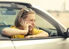 אישה יושבת ברכב ומדברת בטלפון